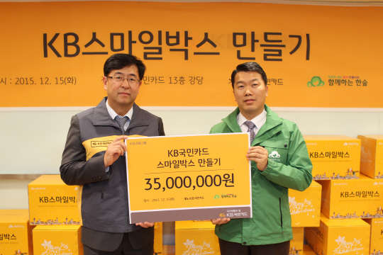 KB국민카드는 서울 종로구 KB국민카드 본사에서 '스마일박스 만들기 봉사활동'을 펼쳤다고 15일 밝혔다. 이날 백문일 KB국민카드 상무(왼쪽)가 권훈상 함께하는 한숲 이사장에서 기부금을 전달하고 있는 모습.